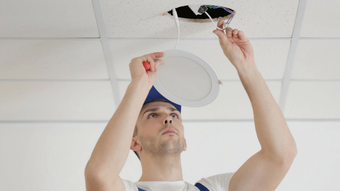 Electrician replacing a recessed