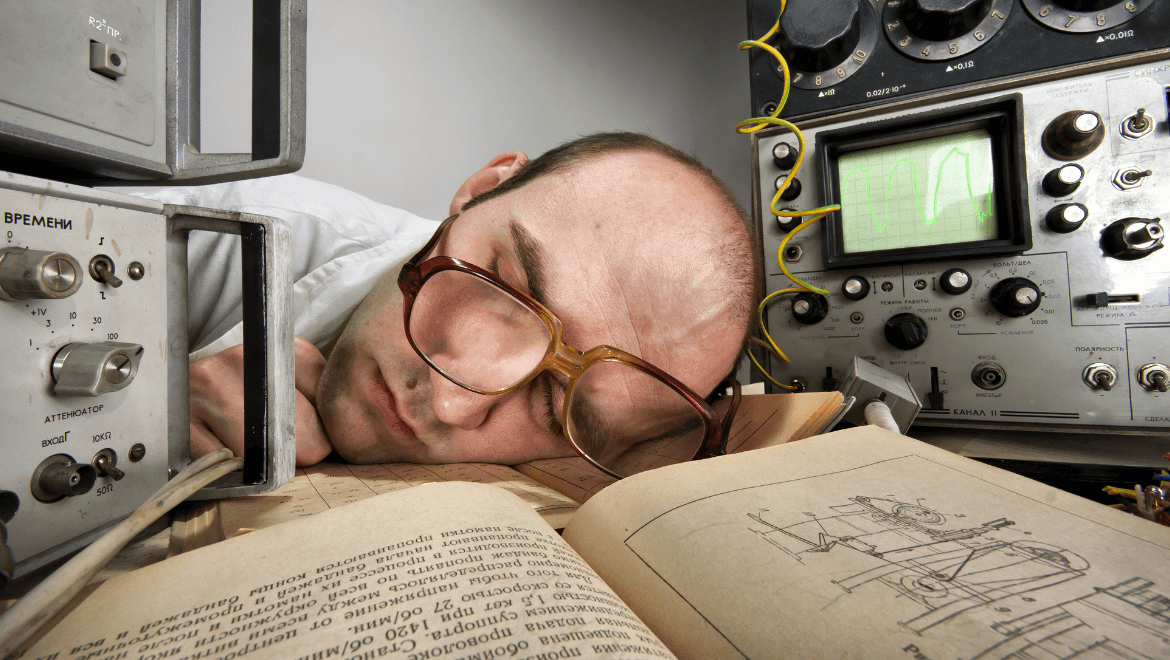 Man with glasses sleeping on his desk with lumen measurement tools